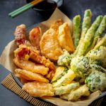 Side view of Japanese vegetable tempura recipe with ginger ponzu sauce , black background with copy space